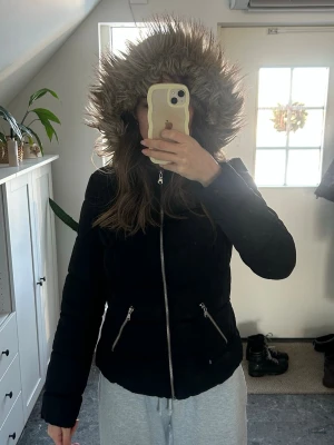 Svart jacka med pälshuva  - Snygg svart vinterjacka 