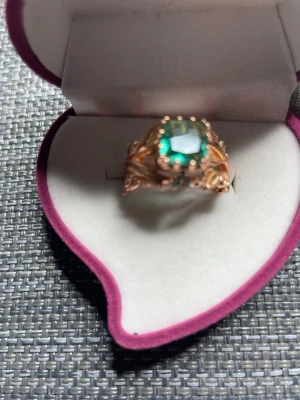 Grön vintageinspirerad ring i mässing last edition ” Nature” - Unik ring med en stor grön sten i mitten och detaljerat blad- och blomsterinspirerat band i guldtonad mässing . Stenen är fyrkantigt slipad och infattningen har små dekorativa detaljer som ger en sagolik känsla. Perfekt för dig som vill sticka ut med något riktigt speciellt.