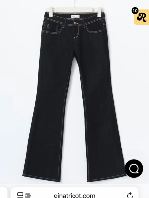 Bootcut jeans från Gina Tricot - Snygga svarta bootcut jeans från Gina Tricot med kontrasterande vita sömmar. Klassisk femficksmodell och knappstängning fram. Jeansen har en stilren look och är tillverkade i jeansmaterial med lite stretch för extra komfort. Aldrig använda