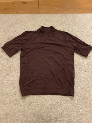 Brun polotröja från Stockh LM XS - Säljer en brun polotröja från Stockh LM i storlek XS. Tröjan har korta ärmar och en klassisk polokrage. Perfekt att styla med jeans eller kjol för en chill look. Materialet känns mjukt och lätt, och färgen är riktigt snygg till hösten.