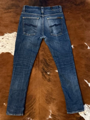 Nudie GrimTim - Tjena! Säljer dessa nudie jeans i modellen GrimTim(slim), byxorna är i fint skick med riktigt snygg tvätt, passar W29/L30, hör av dig vid funderingar!🙌