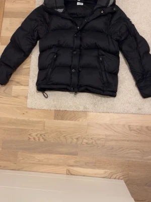 Svart pufferjacka från Burberry - Säljer en svart pufferjacka från Burberry med tydlig logga på ärmen. Perfekt för kalla dagar och har en riktigt schysst streetstil. Jackan är i storlek M men kan även passa S. Priset kan diskuteras!