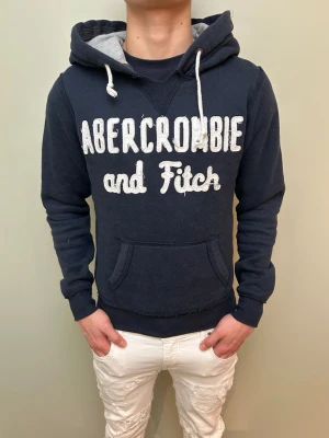 Fet Abercrombie and Fitch hoodie!! - Skön marinblå Abercrombie and Fitch vintage hoodie med bra passform och snygg text framtill!! OBS: Storlek S men passar xs.