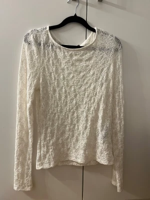 Vit spetsblus från AWARE - Säljer en vit långärmad blus från AWARE. Blusen är helt täckt av vacker spets och har en rund halsringning. Storlek L, men känns mindre i när man väl har på sig den