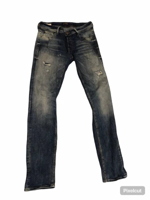 Slim fit blå jeans Glenn 32/34 - Säljer ett par blå slim fit jeans från Glenn i storlek 32/34. Jeansen har slitna detaljer och en snygg tvättad look. Klassisk femficksmodell med raka ben och normal midja. Perfekta för dig som gillar en smalare passform och lite ruffigare stil. Gör en bundle om ni vill ha ett schysst pris.