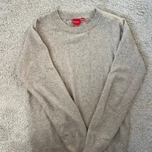 Beige stickad tröja - Tröjan är från RYVLS och väldigt snygg. Den är beige och i skönt material. Den är i storleken 158-164 men är elastisk och man kan ha den vid 170 cm också.