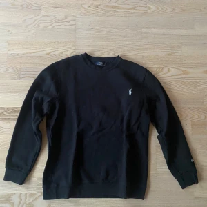 Ralph Lauren sweatshirt  - Svart sweatshirt från Ralph Lauren. Ralph Lauren broderat på ena ärmen. Extremt bra skick på denna, endast använd 1-2 gånger. Storlek L men passar även M. Inga defekter överhuvudtaget. Skicka ett meddelande vid frågor! 