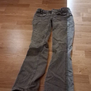 Grå bootcut jeans med fickor i storlek 152 från gina tricot - Säljer ett par grå jeans med klassisk femficksdesign och bootcut-ben. Jeansen har normal passform och är tillverkade i slitstarkt denimtyg. Perfekt för dig som gillar en lite bredare benslut och enkel stil.