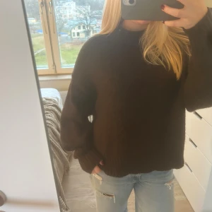 Mörkbrun stickad tröja Gina Tricot - Mysig mörkbrun stickad tröja från Gina Tricot i storlek M. Tröjan har en rund hals, ribbade muddar och långärmade ärmar. 