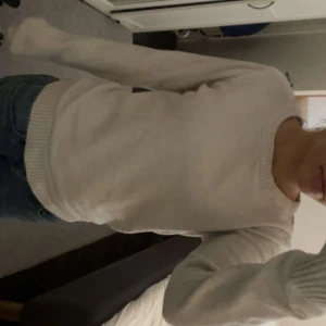Vit stickad tröja  - Enkel och stilren vit stickad tröja med rund halsringning och ribbade muddar vid ärmslut och nederkant. Perfekt att matcha med jeans för en clean look. Långärmad och mjuk, passar till flera säsonger.