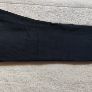 Svarta Heattech byxor från Uniqlo - Säljer ett par svarta Heattech byxor från Uniqlo, perfekta för kyliga dagar. Byxorna har en slim passform och är tillverkade av en mjuk blandning av bomull, rayon, akryl och polyuretan. Snyggt raka ben och stilren look som funkar till många outfits.