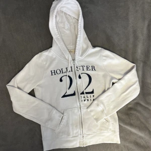Vit zip hoodie från Hollister  - Vit zip hoodie från Hollister, storlek S. Använt men fortfarande bra skick, perfekt nu för höst/vinter❤️