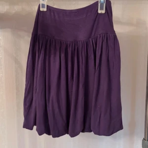 Lila kortkjol från Eve i bomull - Supersöt lila kortkjol från Eve i mjuk bomull. Kjolen har en bred midja och är lätt rynkad för en flowy och avslappnad look. 