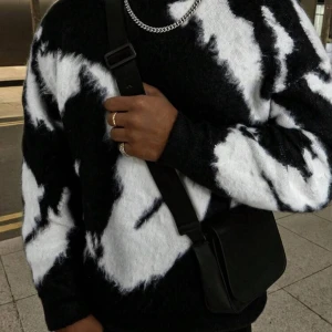 Oversized stickad tröja med mönster - Säljer en oversized stickad tröja med coolt abstrakt mönster i svart och vitt, grön och vit eller grå och svart. Tröjan har långärmad passform och är riktigt mjuk och fluffig, perfekt för att hålla värmen. Passar dig som gillar streetstyle och vill sticka ut.