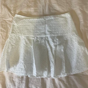 Vit broderad kjol - Superfin vit kortkjol från H&M med broderade mönster. Den har en liten fläck vid sidan men inget som syns mycket vid användning, se sista bilden 