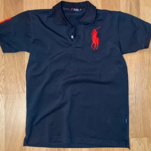 Chief Keef Polo - Stor röd broderad logga med polospelare på bröstet. Broderad 3:a på armen.