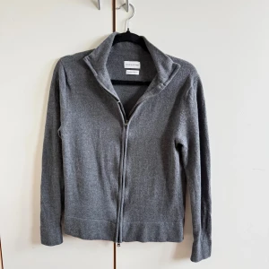 Grå merinoullskofta från These Glory Days - Mysig grå kofta i merinoull från These Glory Days. Koftan har hel dragkedja framtill, hög krage och långa ärmar. Perfekt för lager-på-lager och enkel att matcha med det mesta. Snygg och stilren design som funkar året runt. Mycket bra skick! Pris kan som vanligt diskuteras vid snabb och smidig affär. Storlek medium men passar small. 