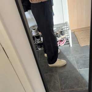 Svarta byxor från ARKET, strl 46 - Säljer ett par svarta byxor från ARKET i storlek 46. Byxorna har en relaxed passform med raka ben och sidfickor.  sköna och luftiga. Perfekta för dig som gillar en clean och enkel stil.