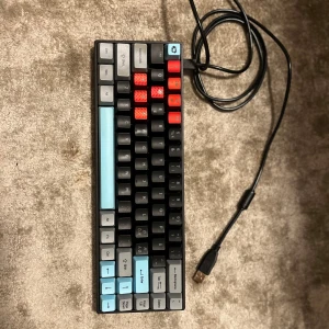 Akko 3068B - Snygg och kompakt Akko 3068B mekaniskt tangentbord med USB-anslutning. Anpassade keycaps i blått, grått och rött ger ett unikt utseende. Tangentbordet är i mycket gott skick, inga defekter eller slitage. Perfekt för gaming eller produktivitet.