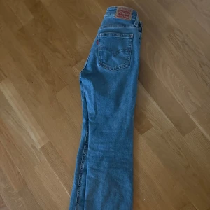 Levi's Superlow Bootcut jeans blå - Utsvängda lågmidjade jeans från Levi’s. Använda ett fåtal gånger. Storlek 23