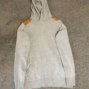 Grå Stickad hoodie - Tja, säljer en grå stickad hoodie med bruna axelpartier för endast 399. Priset är ej hugget i sten och skriv i dm vid frågor eller funderingar! 🙌