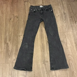 Svarta bootcut jeans från lager 157 - Snygga svarta jeans från lager 157 i modellen Low Boot, storlek XS Short. Jeansen har klassisk femficksdesign, låg midja och bootcut-ben som ger en cool siluett. Materialet är jeans med en lätt tvättad look och silverfärgade nitar vid fickorna. Säljs då dom tyvärr inte kommer till användning!