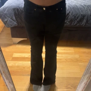 Svarta bootcut jeans från Perfect Jeans Ginatricot - Snygga svarta jeans från Perfect Jeans Ginatricot i storlek 40. Modellen har klassisk femficksdesign, hög midja och bootcut-ben som ger en schysst siluett. Jeansen är tillverkade i stretchigt denim för skön passform och har silverfärgade nitar och knapp framtill.