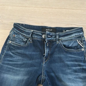 Blå Replay Vicky jeans, storlek 28/32 - Snygga blå jeans från Replay, modell Vicky, med klassisk femficksdesign och kontrastsömmar. Jeansen har raka ben och normal passform, tillverkade i mjukt denim med lätt slitning för en cool look. Perfekt för dig som gillar stilrena och bekväma jeans.