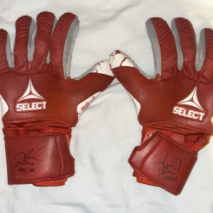Röda målvaktshandskar från Select - Säljer ett par röda målvaktshandskar med Peter cech signatur på. Behöver ni bevis om att jag träffat han kan jag fixa de intressant lämna dm