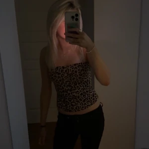 Leopardmönstrad tubtopp - Säljer en snygg leopardmönstrad tubtopp med bandeau-stil. Toppen är tight och croppad, perfekt för dig som vill sticka ut. Färgerna går i beige, brun och svart och materialet känns mjukt och följsamt mot kroppen. 