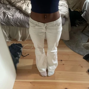 Vita bootcut jeans med låg midja - Säljer ett par vita jeans med snygg bootcut och låg midja. Längd 98cm innerbenslängd 77cm Midja 37 