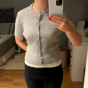 Grå kofta från Zara - Säljer en stilren grå kofta från Zara med korta ärmar och knappar framtill. Perfekt för lager-på-lager och passar till många olika outfits. 🩶