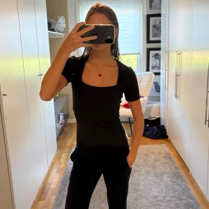 Svart topp med fyrkantig ringning - En svart T-shirt med fyrkantig ringning 