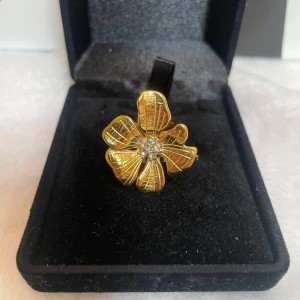 Guldig blomring med diamanter  - Unik ring i guldtonad metall formad som en blomma med detaljerade blad och små glittrande stenar i mitten. Justerbar storlek och riktigt statement-piece för dig som vill sticka ut med din stil. Rostfri 🤗