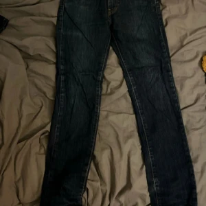 Levi's Premium mörkblå jeans straight - Mörkblå Levi's Premium jeans med klassisk femficksdesign och snygga ben. Sitter bra med storlek W 28 L 32.