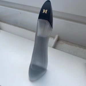 Carolina Herrera Good Girl Hairmist - Snygg parfymflaska formad som en klack, perfekt för dig som vill sticka ut på hyllan. En ikonisk design från Carolina Herrera som snabbt blivit en favorit bland många. Toppnoter: MandelHjärtnoter: Tuberos & Jasmin SambacBasnoter: Tonkabönor & Kakao                   Nypris: 495kr 