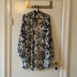 Blommig kimono från Divided, stl L - Säljer en luftig, blommig kimono från Divided i storlek L. Blusen är öppen framtill. 