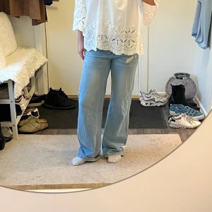 Ljusblå wide jeans med rak passform - Säljer ett par ljusblå jeans med breda ben och rak passform. Jeansen har klassisk femficksdesign och är tillverkade i mjukt denimtyg. Perfekta för en avslappnad och trendig look. Har fått lite slitage längst nere vid benen men inget som märks mycket