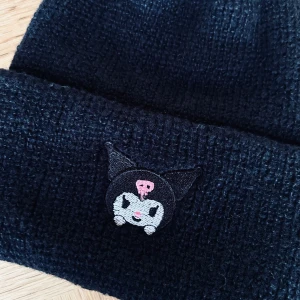 Svart stickad mössa med Kuromi-motiv! - Svart stickad mössa med Kuromi broderad framtill. Onesize (passar både barn och vuxna). Oanvänd.