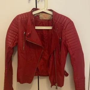 Röd skinnjacka stl 36 - Snygg röd skinnjacka från Voyelles i storlek 36. Dåligt skick på grund av defekter (se bilder). 