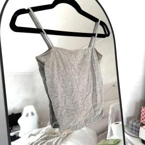 Grå linnetopp - En enkel och stilren grå linnetopp från H&M Divided i storlek XS. Toppen har tunna axelband och är tillverkad i mjuk bomullsmix.