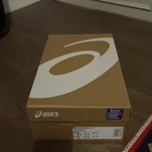 ASICS Gel-Kayano 14 silver/vita sneakers - ASICS Gel-Kayano 14 sneakers i silver och vitt med svarta detaljer. Skorna har en sportig mesh- och syntetöverdel, snörning och en chunky sula med svart och vit yttersula. Perfekta för dig som gillar retrovibbar och streetstyle. Storlek 43.5