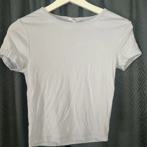 Ljusblå kortärmad topp från Gina Tricot - En basic ljusblå topp från Gina Tricot, basically basics-kollektionen. T-shirten har rund halsringning och korta ärmar. Enkel och stilren modell i mjuk bomull, perfekt att matcha med allt.