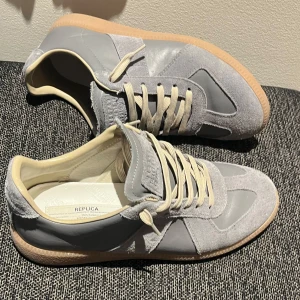 Gråa maison margiela - Tar gärna trades!  Säljer mina gråa Maison Margiela GATs i storlek 42. De är i bra skick, inte alls mycket använda. Riktigt sköna och passar till typ allt.
