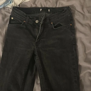 Svarta bootcut jeans från Gina  - Säljer ett par svarta jeans med bootcut-modell. Klassisk femficksdesign, dragkedja och knapp framtill. Jeansen har en något utsvängd benslut och är tillverkade i ett robust denimtyg. Perfekta för dig som gillar en tidlös och avslappnad stil. Skulle säga att de är lowwaist men inte som weekday jeansen