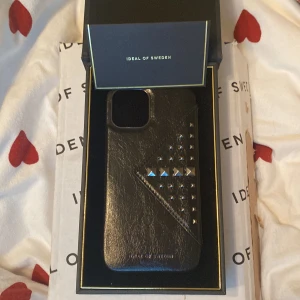 iDeal of Sweden Svart Läderfodral med Nitar - Priset går att förhandla. Elegant svart läderfodral från iDeal of Sweden med dekorativa nitar. Passar iPhone 12.  Levereras i originalförpackning, helt ny aldrig använt. 