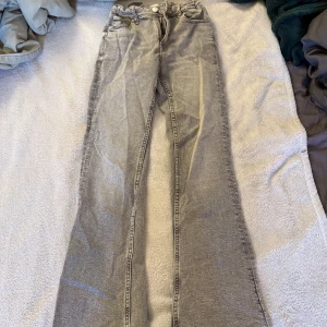 Grå jeans från Gina Tricot, stl 158 - Snygga grå jeans från Gina Tricot i storlek 158. Modellen har raka ben och klassisk femficksdesign. Jeansen är i mjukt denimtyg och har justerbar midja med resår och knapp på insidan för perfekt passform.