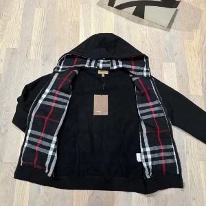 Svart burberry zip hoodie  - Snygg svart burberry zip hoodie i storlek S. Nyskick med tags kvar. Perfekt nu till det kalla vädret. Hör av er vid funderingar!