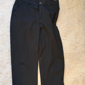 Svarta kostymbyxor med raka ben -  Svarta kostymbyxor med klassisk passform och raka ben. Byxorna stängs med knapp och dragkedja. Perfekta för en clean och stilren look. Storlek XS köpt på lager 157🥰