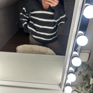 Randig stickad tröja från Pieces - Mysig stickad tröja från Pieces i mörkgrått med vita horisontella ränder. Tröjan har v-ringning, krage och långa ärmar. Perfekt för lager-på-lager och chill dagar. Oversized fit för en avslappnad look.